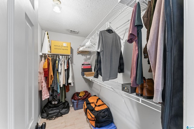 walk in closet with visible vents and wood finished floors