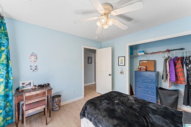 bedroom featuring baseboards, wood finished floors, and a ceiling fan