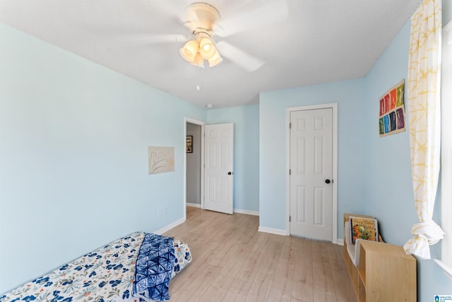 bedroom with ceiling fan, baseboards, and wood finished floors