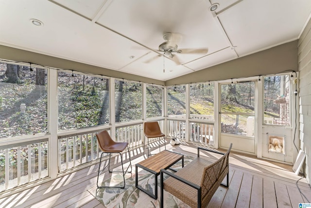 sunroom / solarium with vaulted ceiling, plenty of natural light, and ceiling fan