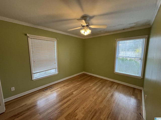 unfurnished room with ornamental molding and wood finished floors