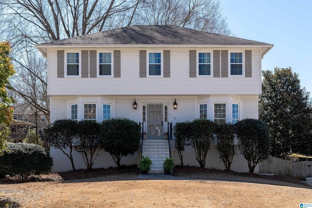 colonial-style house with brick siding and fence