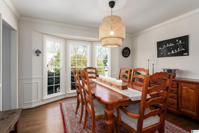 dining area featuring wood finished floors and crown molding