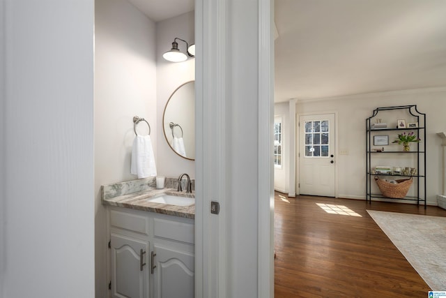 bathroom with vanity, baseboards, and wood finished floors