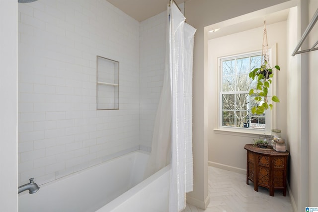 bathroom with plenty of natural light, shower / bath combo with shower curtain, and baseboards