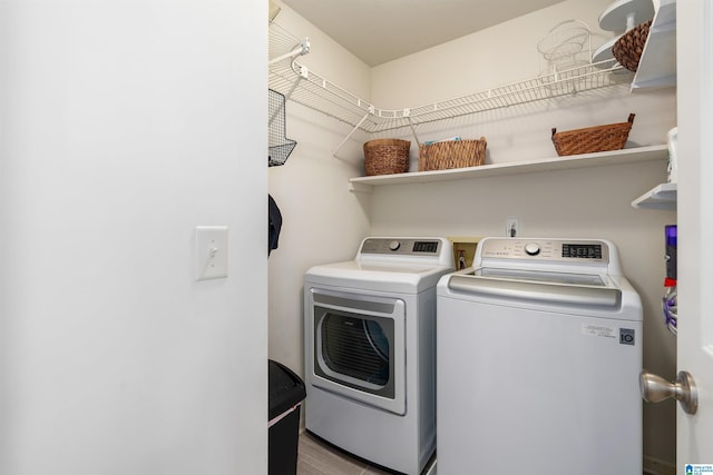 washroom featuring washer and clothes dryer, laundry area, and wood finished floors