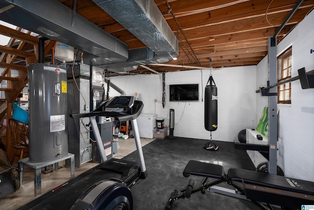 exercise area with water heater and concrete block wall