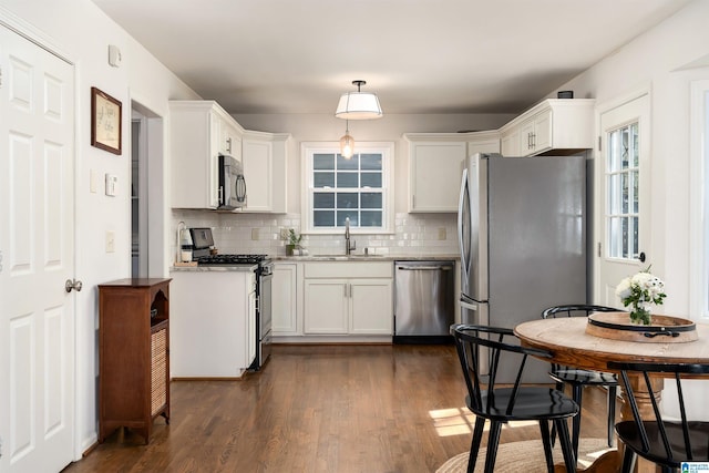 kitchen featuring a sink, appliances with stainless steel finishes, white cabinets, and dark wood-style flooring