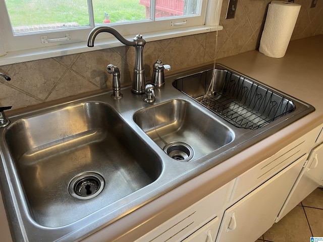 interior details featuring backsplash and a sink