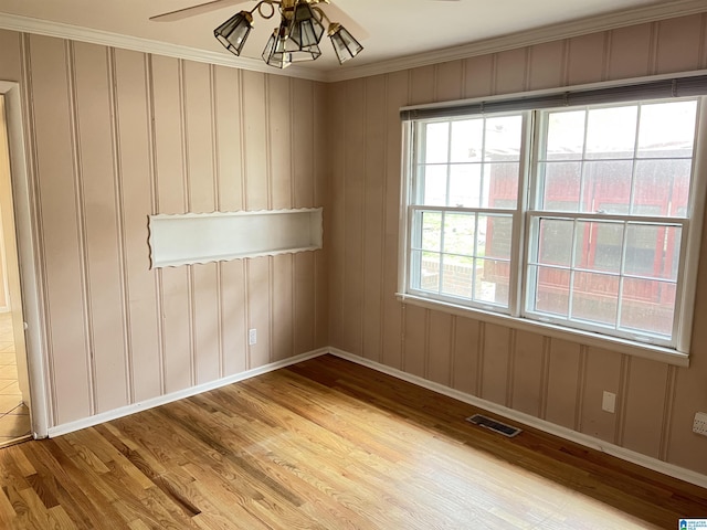 empty room with light wood finished floors, visible vents, baseboards, and a ceiling fan