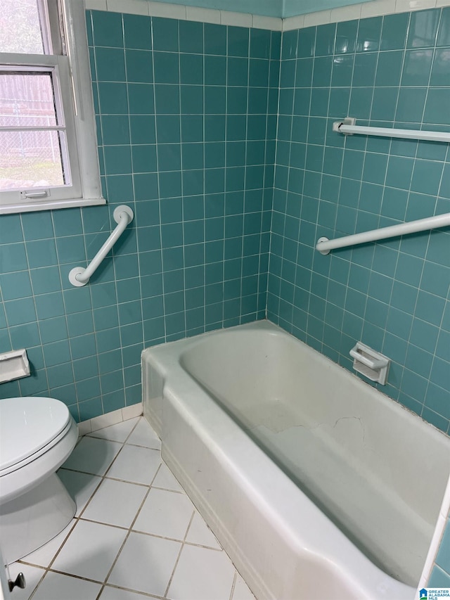 full bathroom with tile patterned floors, toilet, and tile walls