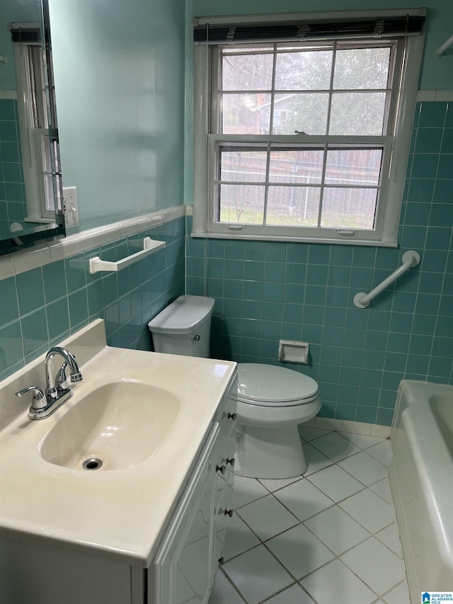 bathroom with a wealth of natural light, toilet, a tub, and tile patterned floors