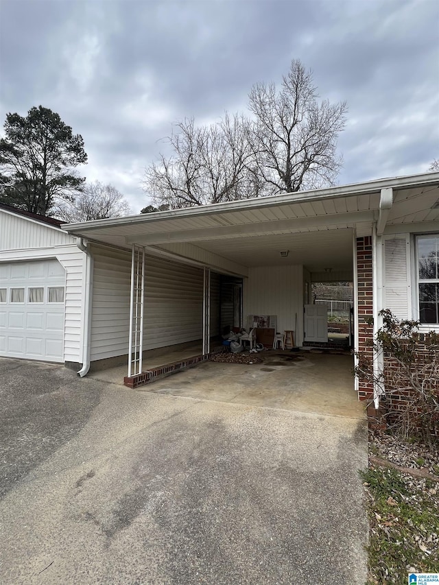 view of vehicle parking with aphalt driveway and a carport