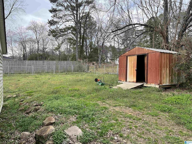 view of yard with a storage shed, a fenced backyard, and an outdoor structure