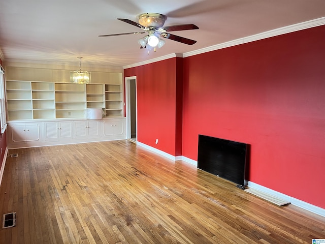 unfurnished living room featuring visible vents, baseboards, ornamental molding, and hardwood / wood-style flooring