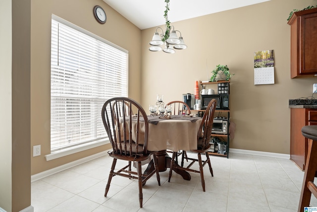 dining space with an inviting chandelier, light tile patterned floors, and baseboards