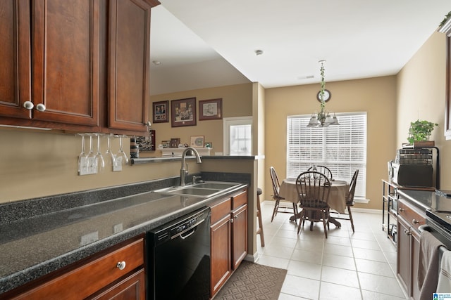 kitchen with light tile patterned floors, a sink, pendant lighting, dishwasher, and dark countertops