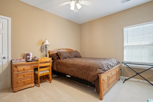 bedroom with light carpet, visible vents, and a ceiling fan