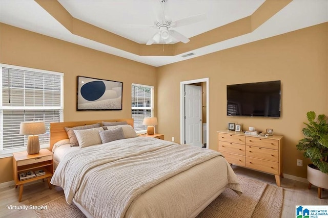 1055 Windsor Pkwy, Moody, AL 35004 - bedroom featuring light wood-style floors, baseboards, a tray ceiling, and a ceiling fan