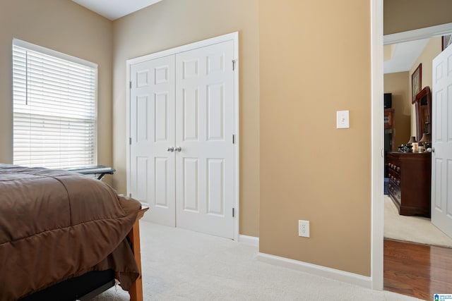 bedroom with a closet, baseboards, and carpet