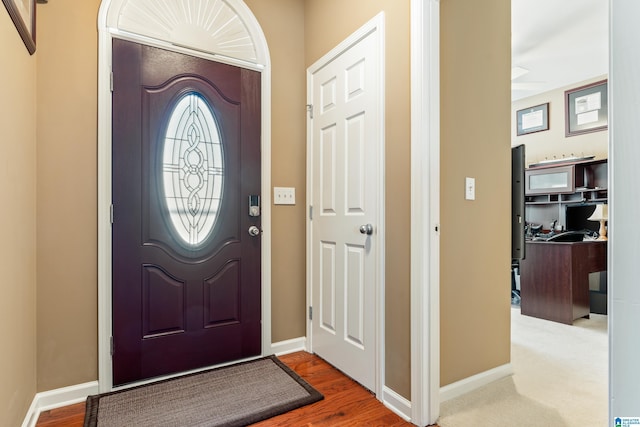 foyer featuring wood finished floors and baseboards