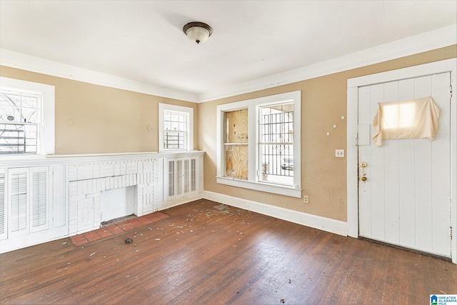 entryway with baseboards, crown molding, a fireplace, and hardwood / wood-style flooring