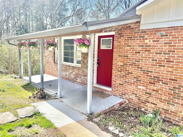 entrance to property featuring brick siding