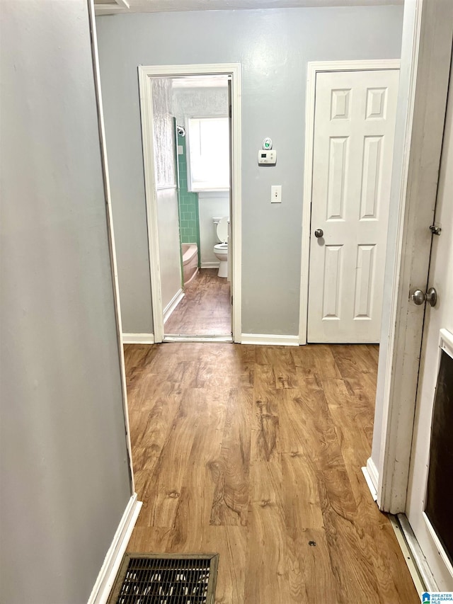 corridor featuring baseboards and light wood-style floors