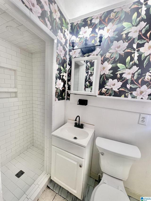 bathroom with vanity, wallpapered walls, a shower stall, a decorative wall, and toilet