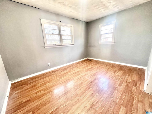 unfurnished room with baseboards and wood finished floors