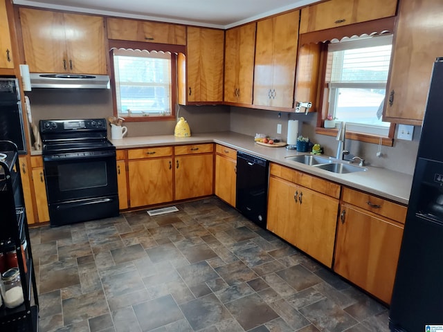 kitchen with extractor fan, light countertops, plenty of natural light, black appliances, and a sink