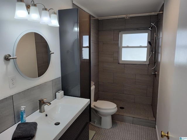 bathroom featuring vanity, toilet, tile patterned flooring, and tiled shower