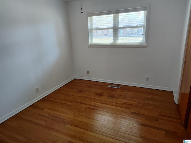 unfurnished bedroom featuring visible vents, baseboards, and wood finished floors