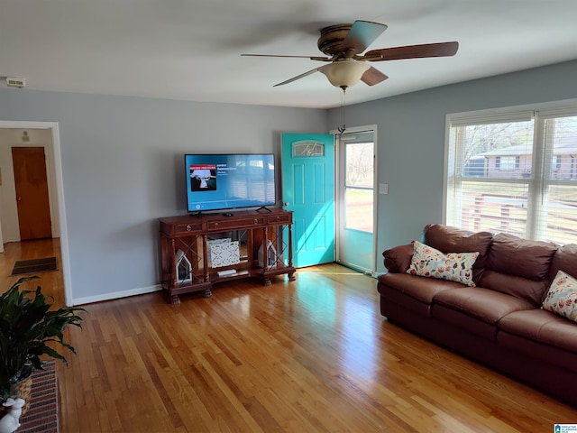 living room with wood finished floors, baseboards, and ceiling fan