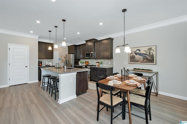 kitchen with dark brown cabinets, an island with sink, decorative backsplash, a kitchen breakfast bar, and stainless steel appliances