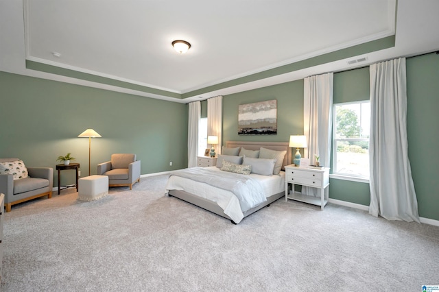 bedroom with baseboards, carpet, a tray ceiling, and ornamental molding