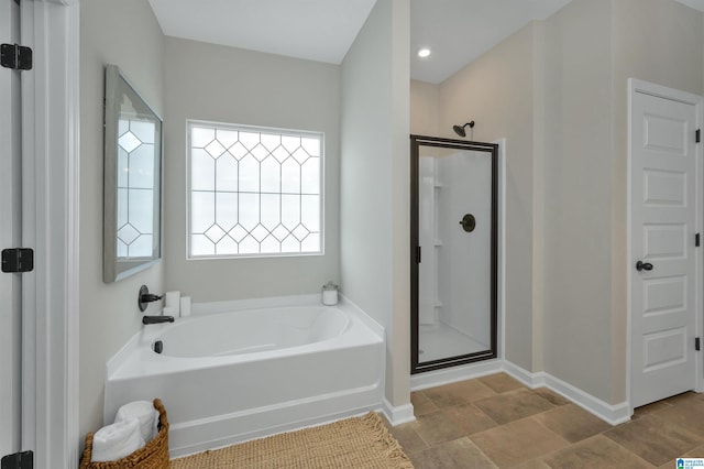 full bathroom with a garden tub, baseboards, and a stall shower