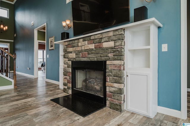 details featuring a fireplace, baseboards, and wood finished floors