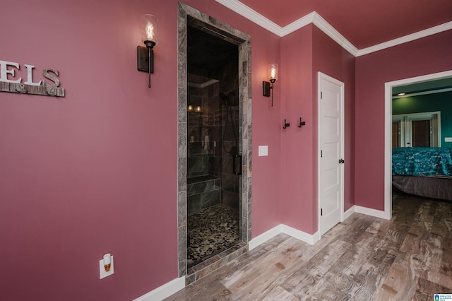 hall featuring ornamental molding, baseboards, and wood finished floors