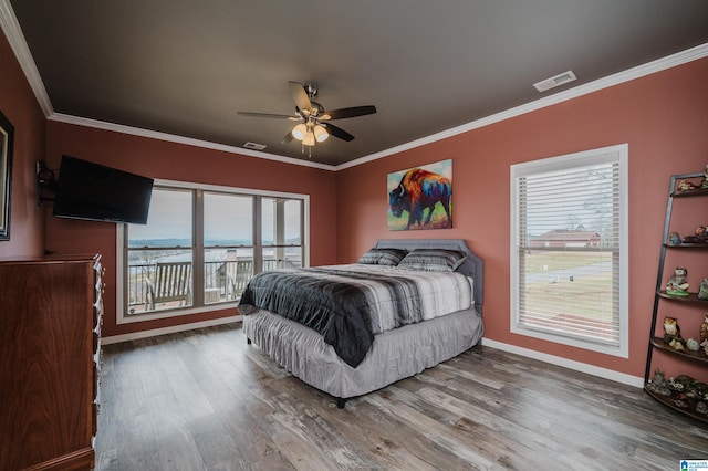 bedroom with crown molding, wood finished floors, and visible vents