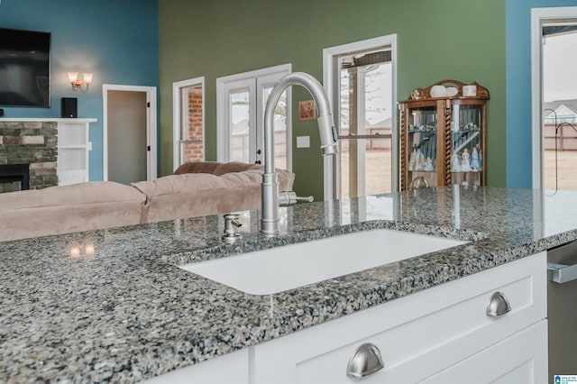 interior details with a stone fireplace and a sink