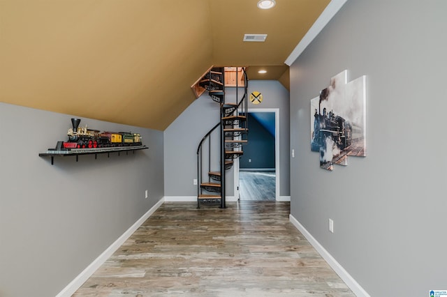 interior space with visible vents, baseboards, wood finished floors, and stairs