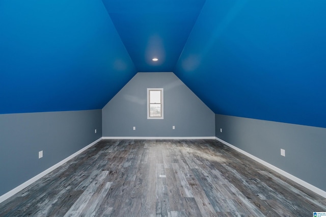 bonus room with baseboards, lofted ceiling, and dark wood finished floors