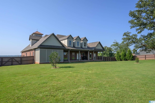 back of property featuring a fenced backyard, brick siding, and a yard