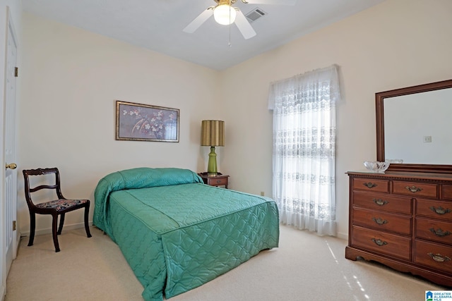 bedroom featuring visible vents, light carpet, baseboards, and a ceiling fan