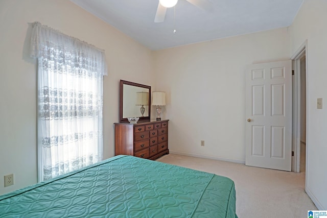 bedroom with a ceiling fan, light colored carpet, and baseboards