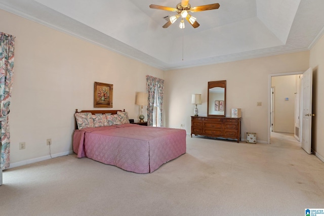 carpeted bedroom with a raised ceiling, baseboards, and ornamental molding