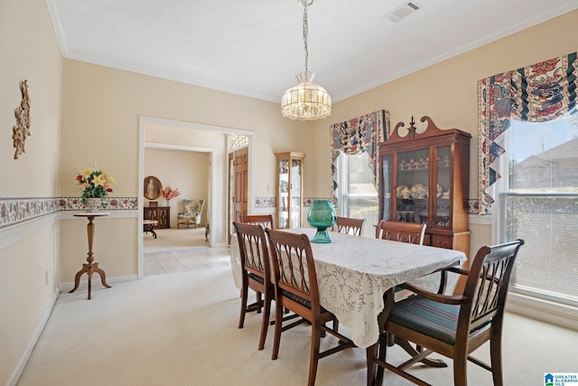 dining space featuring baseboards, visible vents, light carpet, crown molding, and a notable chandelier