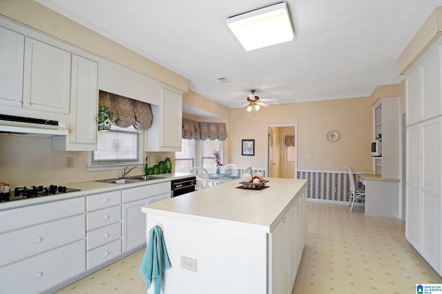 kitchen with a sink, light floors, black appliances, and under cabinet range hood