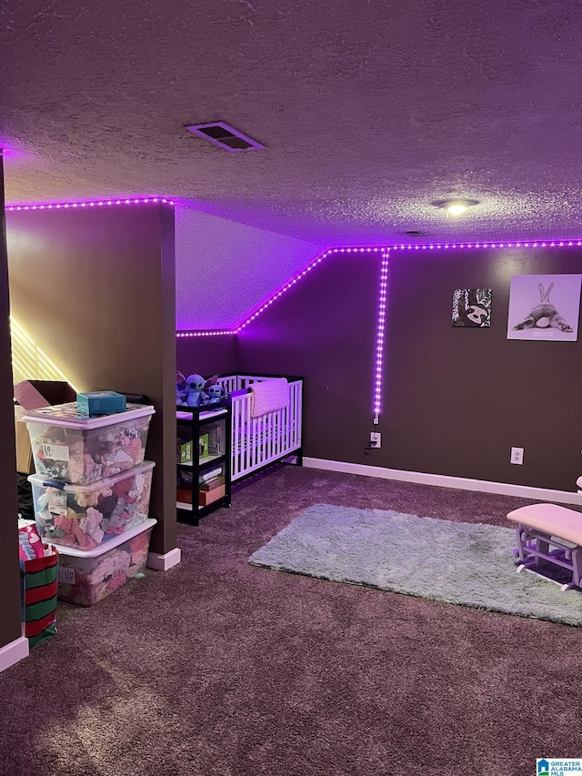 carpeted bedroom with visible vents, baseboards, and a textured ceiling
